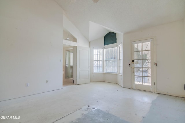 unfurnished room with a textured ceiling and vaulted ceiling