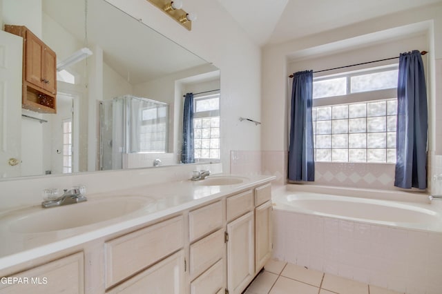 bathroom with tile patterned flooring, vanity, a wealth of natural light, and vaulted ceiling