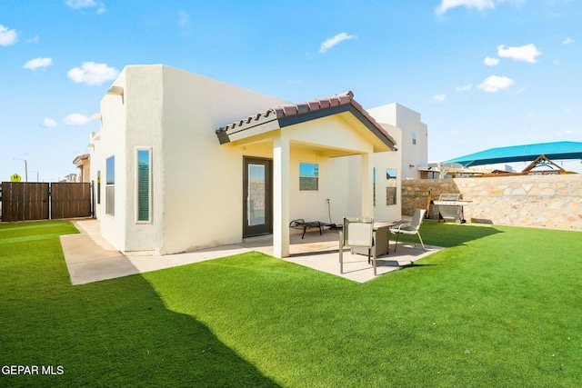 rear view of house with a yard and a patio area