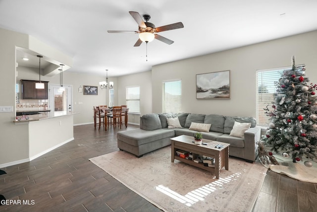 living room featuring ceiling fan with notable chandelier