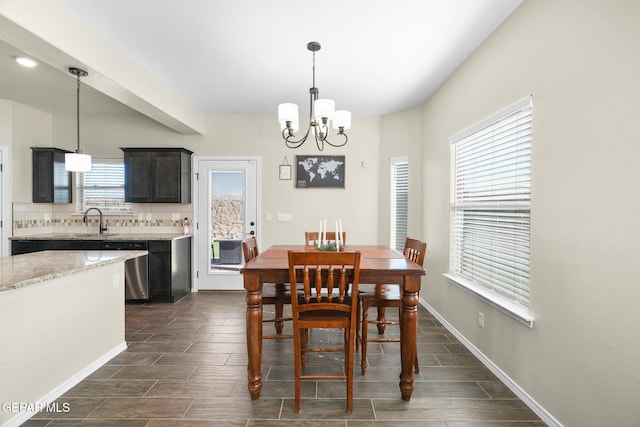 dining room with a healthy amount of sunlight, sink, and a chandelier