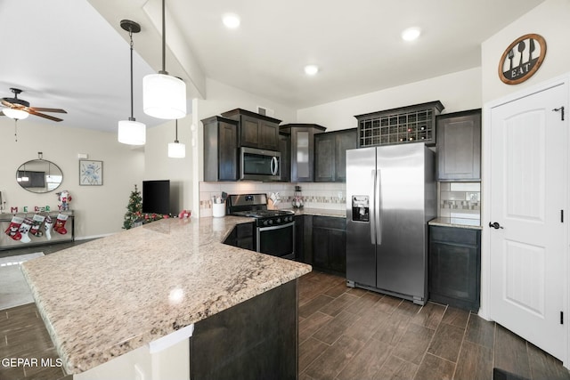 kitchen with kitchen peninsula, hanging light fixtures, ceiling fan, dark brown cabinetry, and stainless steel appliances