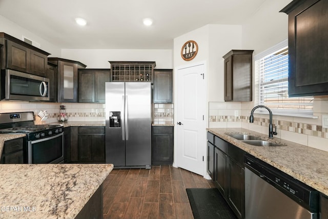 kitchen featuring decorative backsplash, sink, dark brown cabinets, and appliances with stainless steel finishes