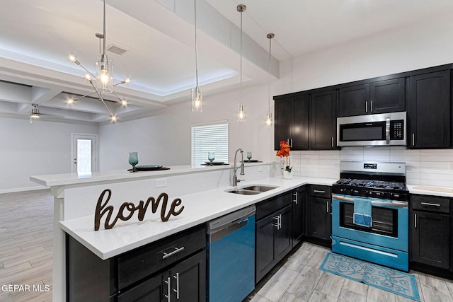 kitchen featuring pendant lighting, sink, kitchen peninsula, and stainless steel appliances