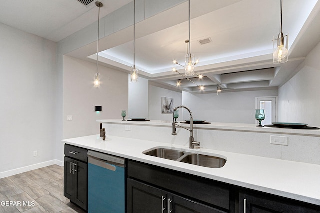 kitchen featuring a raised ceiling, sink, light hardwood / wood-style flooring, stainless steel dishwasher, and decorative light fixtures