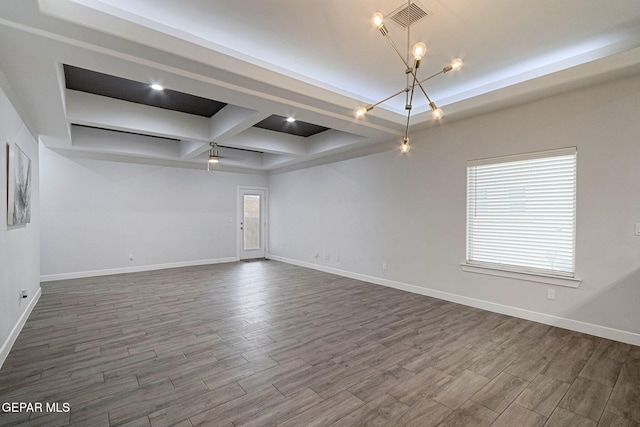 empty room featuring beam ceiling, a tray ceiling, an inviting chandelier, and coffered ceiling