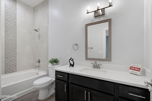 full bathroom with hardwood / wood-style floors, vanity, toilet, and tiled shower / bath