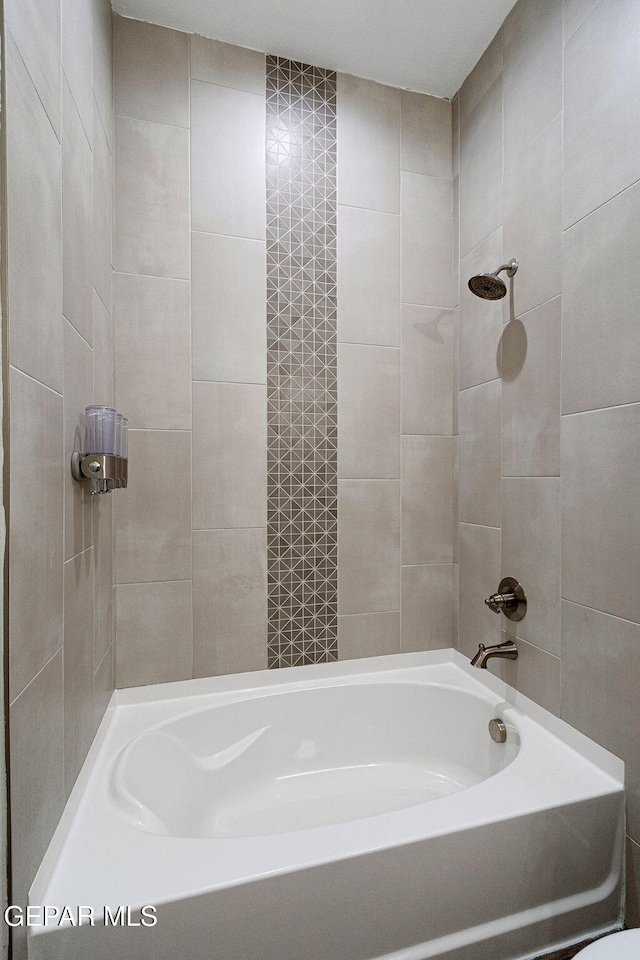 bathroom featuring tiled shower / bath