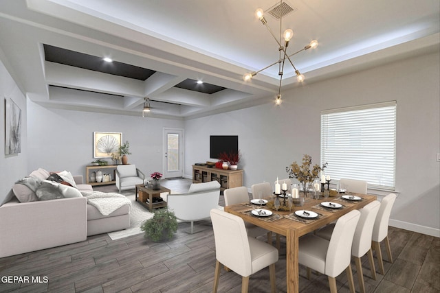 dining space featuring beamed ceiling, an inviting chandelier, a raised ceiling, and coffered ceiling