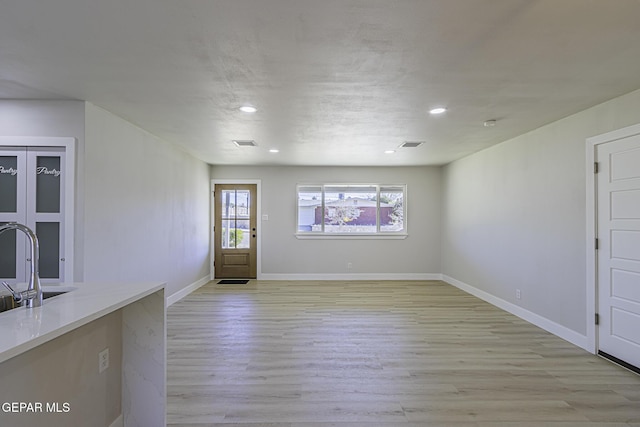 empty room with light wood-type flooring and sink