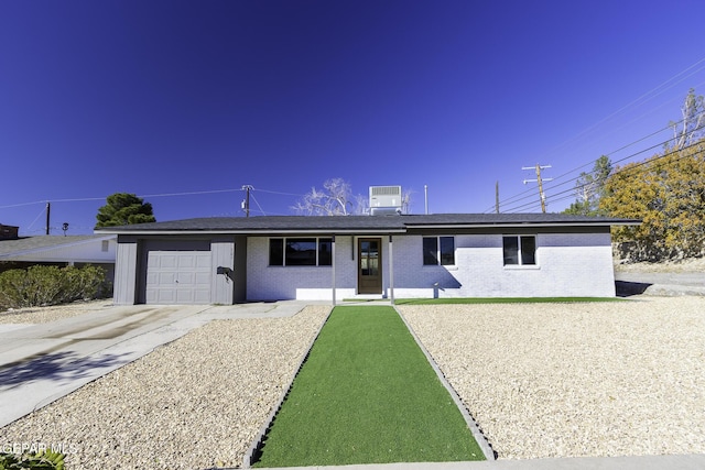 ranch-style home with central AC unit, a carport, and a garage