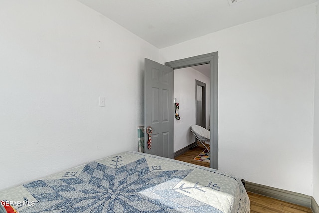 bedroom with hardwood / wood-style flooring