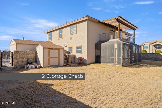 back of house with a balcony and a storage shed