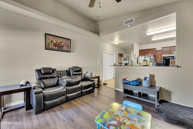 living room featuring ceiling fan and light hardwood / wood-style flooring