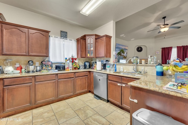 kitchen featuring light tile patterned floors, ceiling fan, light stone countertops, stainless steel dishwasher, and sink