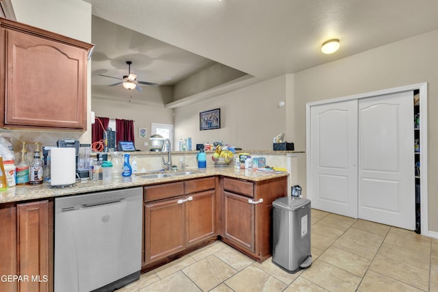 kitchen featuring light stone countertops, sink, kitchen peninsula, ceiling fan, and stainless steel dishwasher