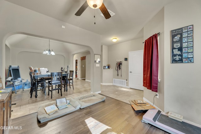 interior space featuring ceiling fan with notable chandelier and wood-type flooring