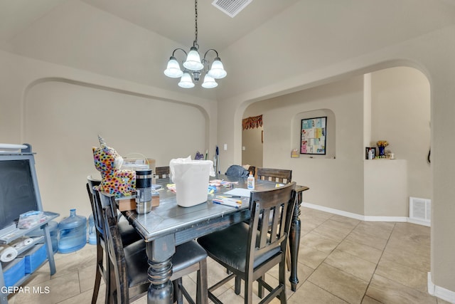 dining space featuring vaulted ceiling, light tile patterned floors, and an inviting chandelier