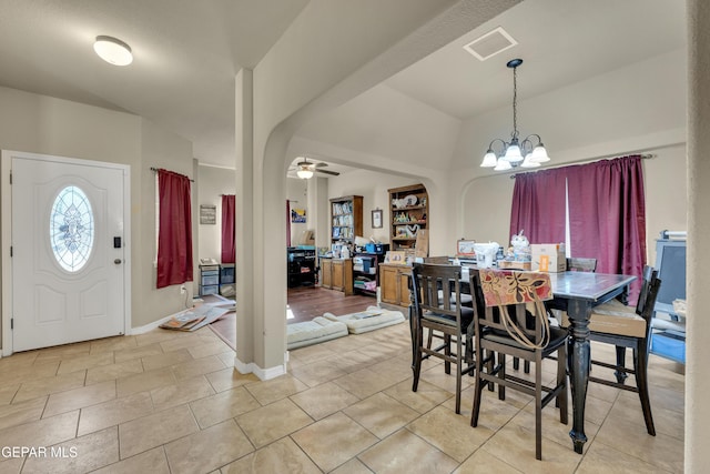 dining area with light tile patterned flooring and ceiling fan with notable chandelier