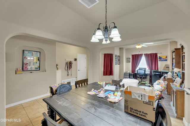 dining area featuring ceiling fan with notable chandelier, light tile patterned floors, and lofted ceiling