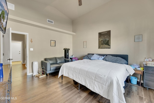 bedroom with ceiling fan, wood-type flooring, and vaulted ceiling