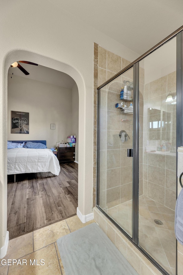 bathroom featuring ceiling fan and an enclosed shower