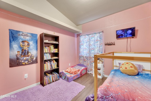 bedroom with hardwood / wood-style floors and lofted ceiling