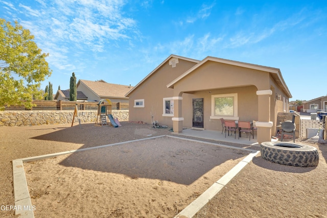 back of house with a playground