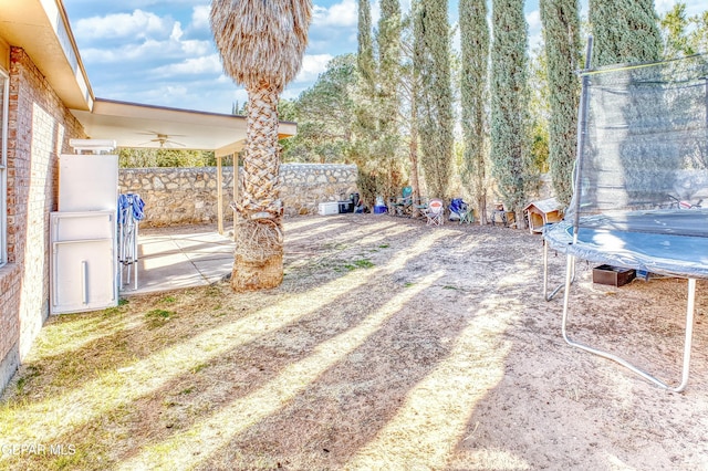 view of yard with a trampoline, a patio area, and a fenced backyard