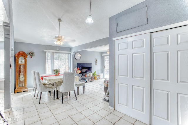 dining space with light tile patterned floors, a textured ceiling, a ceiling fan, and a wealth of natural light