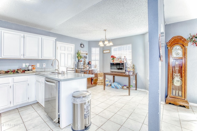 kitchen with light countertops, stainless steel dishwasher, white cabinetry, a sink, and a peninsula