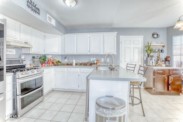 kitchen with visible vents, range with two ovens, light countertops, under cabinet range hood, and a sink