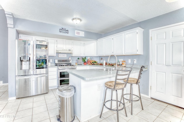 kitchen featuring stainless steel appliances, light countertops, visible vents, a sink, and under cabinet range hood