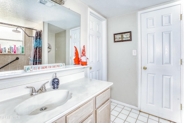 bathroom with curtained shower, visible vents, a textured ceiling, vanity, and tile patterned floors