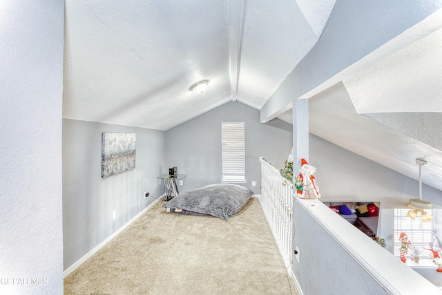 carpeted bedroom featuring vaulted ceiling, a textured ceiling, and baseboards