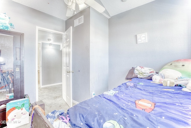 carpeted bedroom with visible vents, a textured wall, a textured ceiling, and baseboards