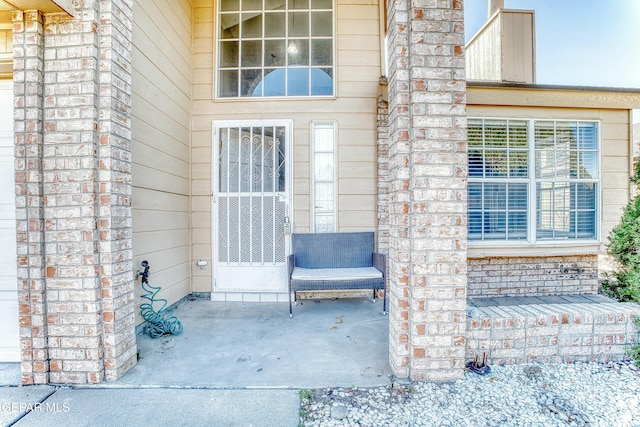 doorway to property featuring brick siding