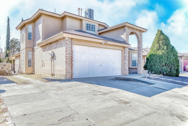 view of front of home featuring driveway, brick siding, and an attached garage