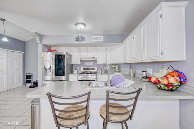 11948 Mcauliffe Dr, El Paso, TX 79936 - kitchen with stainless steel appliances, under cabinet range hood, a sink, light countertops, and a textured ceiling
