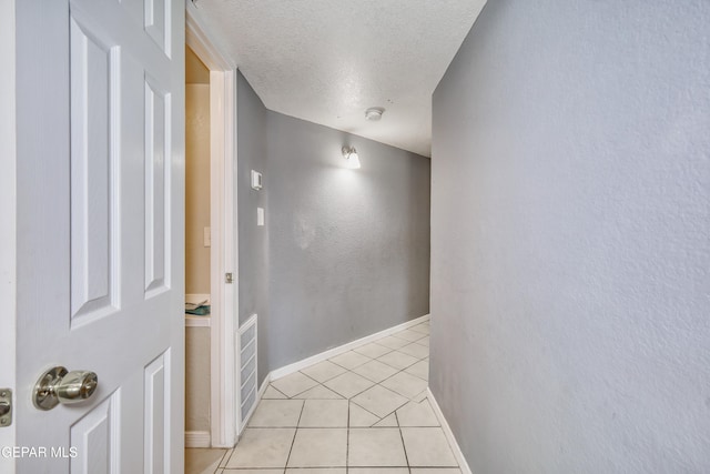 11948 Mcauliffe Dr, El Paso, TX 79936 - hall with a textured ceiling, light tile patterned flooring, and baseboards
