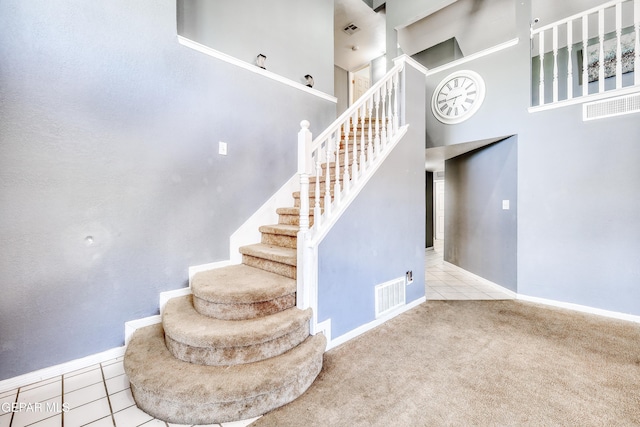 11948 Mcauliffe Dr, El Paso, TX 79936 - stairs with tile patterned floors, baseboards, a towering ceiling, and carpet floors