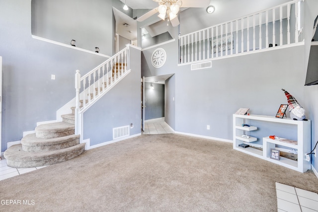 11948 Mcauliffe Dr, El Paso, TX 79936 - unfurnished living room with stairs, carpet flooring, a high ceiling, and ceiling fan