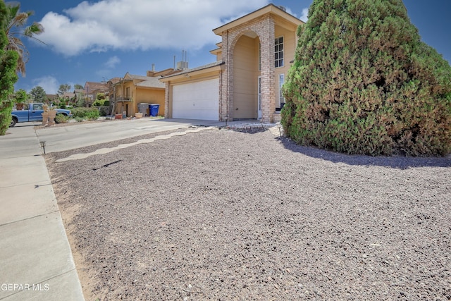 11948 Mcauliffe Dr, El Paso, TX 79936 - view of front of house with driveway, brick siding, and a garage