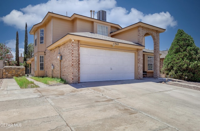 11948 Mcauliffe Dr, El Paso, TX 79936 - view of front of house featuring an attached garage, brick siding, driveway, and central AC unit