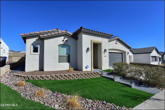 mediterranean / spanish-style house featuring a front yard and a garage