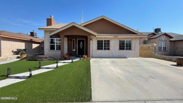 ranch-style home featuring a front lawn and central AC