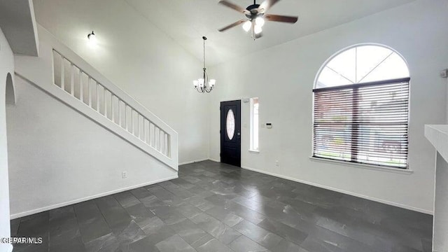 foyer entrance with ceiling fan with notable chandelier and lofted ceiling