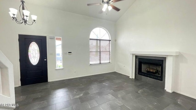 entrance foyer with ceiling fan with notable chandelier and high vaulted ceiling