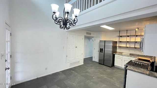 kitchen with a chandelier, appliances with stainless steel finishes, decorative light fixtures, and white cabinetry