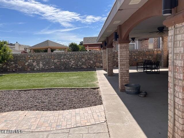 view of yard featuring ceiling fan and a patio area